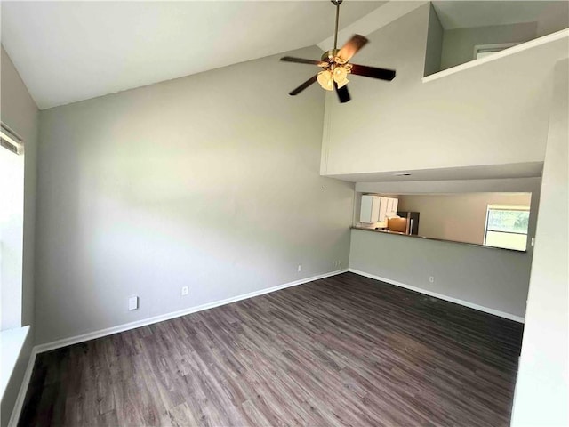 7134 Agnes Ave, Kansas City, MO 64132 - unfurnished living room with dark wood-type flooring, ceiling fan, baseboards, and high vaulted ceiling
