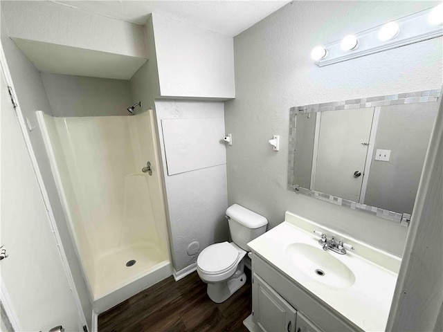 7134 Agnes Ave, Kansas City, MO 64132 - full bathroom with wood finished floors, a shower stall, toilet, and vanity