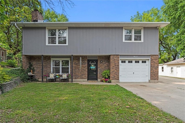 917 L St, Atchison, KS 66002 - view of front of property with a front yard, a chimney, driveway, and a garage