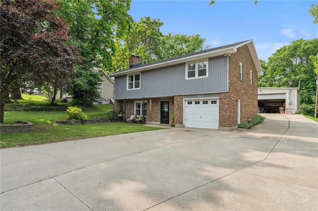 917 L St, Atchison, KS 66002 - view of front of property with a chimney, brick siding, a front lawn, concrete driveway, and a garage