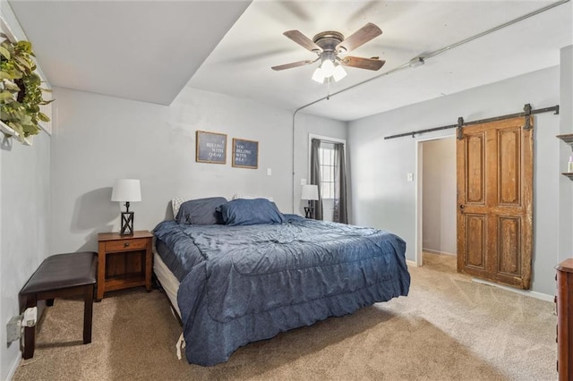 917 L St, Atchison, KS 66002 - bedroom with light carpet, a barn door, a ceiling fan, and baseboards