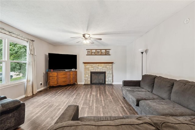 917 L St, Atchison, KS 66002 - living room with wood finished floors, ceiling fan, baseboards, a fireplace, and a textured ceiling