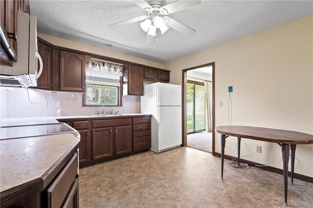 120 Highland Rd, Lansing, KS 66043 - kitchen featuring white appliances, a sink, dark brown cabinets, decorative backsplash, and a ceiling fan
