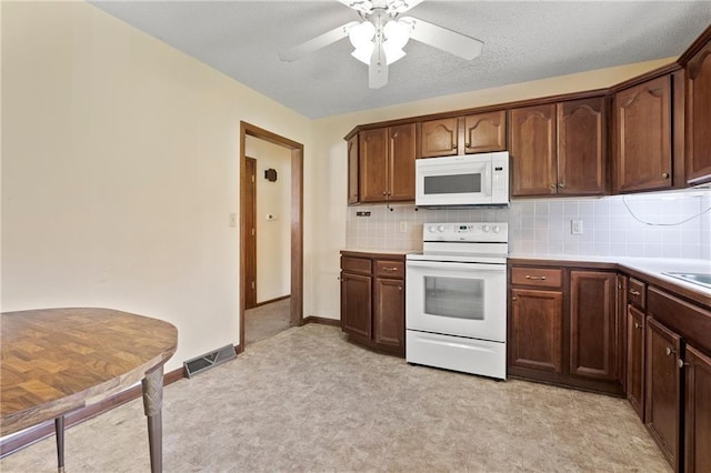 120 Highland Rd, Lansing, KS 66043 - kitchen featuring white appliances, light floors, light countertops, a ceiling fan, and decorative backsplash