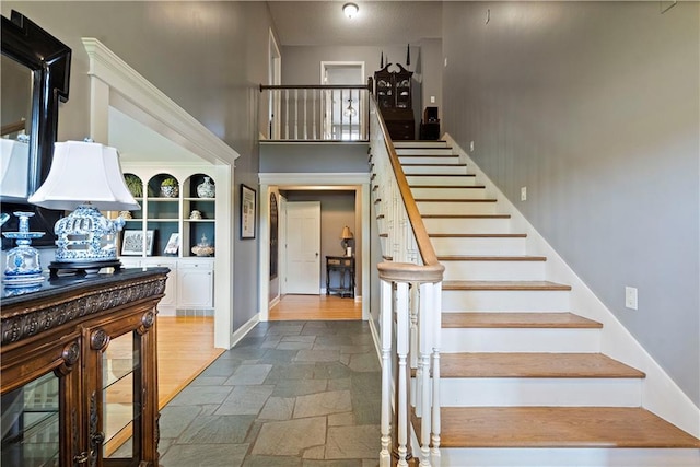 450 Ruth Ewing Rd, Liberty, MO 64068 - stairway with stone tile flooring, a towering ceiling, and baseboards