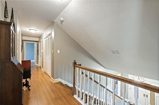 450 Ruth Ewing Rd, Liberty, MO 64068 - hall with a textured ceiling, light wood finished floors, an upstairs landing, and baseboards