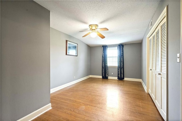 450 Ruth Ewing Rd, Liberty, MO 64068 - unfurnished bedroom featuring wood finished floors, baseboards, a closet, and a textured ceiling