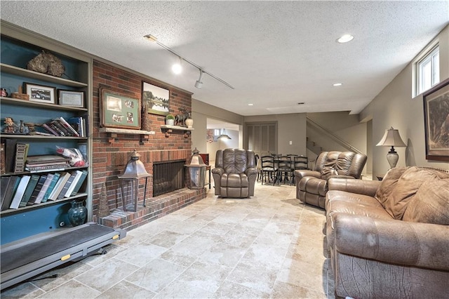 450 Ruth Ewing Rd, Liberty, MO 64068 - living room with a textured ceiling, a fireplace, stairway, and track lighting