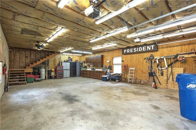450 Ruth Ewing Rd, Liberty, MO 64068 - garage featuring a workshop area, a garage door opener, and wood walls