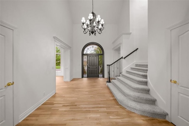 14005 Dearborn St, Overland Park, KS 66223 - entryway with a towering ceiling, a chandelier, light wood-style flooring, and stairway