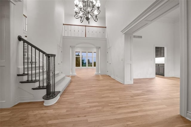 14005 Dearborn St, Overland Park, KS 66223 - foyer entrance with a high ceiling, a chandelier, light wood-style floors, stairway, and arched walkways