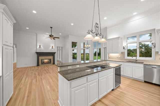 14005 Dearborn St, Overland Park, KS 66223 - kitchen featuring dishwasher, black electric stovetop, a glass covered fireplace, light wood finished floors, and ornamental molding
