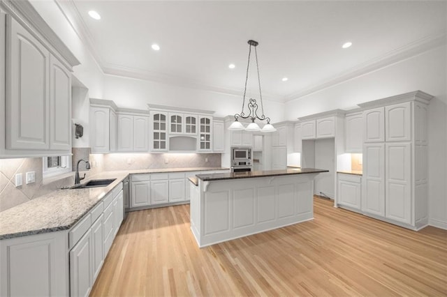 14005 Dearborn St, Overland Park, KS 66223 - kitchen featuring stainless steel appliances, light wood-type flooring, a center island, glass insert cabinets, and backsplash