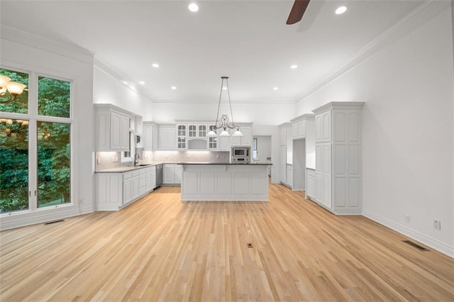 14005 Dearborn St, Overland Park, KS 66223 - kitchen featuring stainless steel appliances, light wood-style floors, backsplash, ceiling fan, and glass insert cabinets