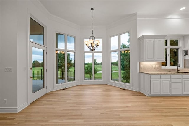 14005 Dearborn St, Overland Park, KS 66223 - unfurnished dining area with light wood-style flooring, a chandelier, and ornamental molding