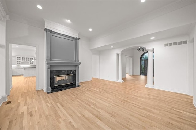 14005 Dearborn St, Overland Park, KS 66223 - unfurnished living room with decorative columns, ornamental molding, light wood finished floors, a high end fireplace, and recessed lighting