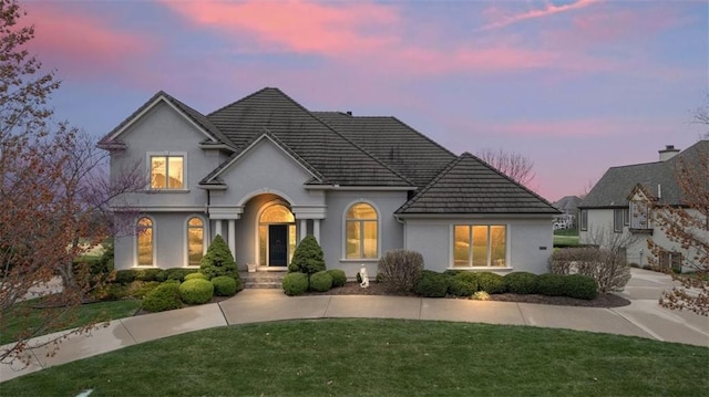 14005 Dearborn St, Overland Park, KS 66223 - view of front of home featuring a tile roof, a front lawn, and stucco siding