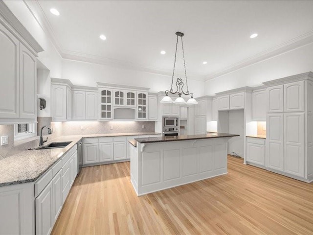 14005 Dearborn St, Overland Park, KS 66223 - kitchen with appliances with stainless steel finishes, a center island, light wood-style flooring, decorative backsplash, and ornamental molding