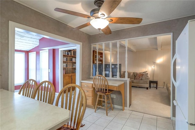 300 S Silver Top Ln, Raymore, MO 64083 - dining room featuring beam ceiling, light tile patterned floors, a ceiling fan, and light colored carpet