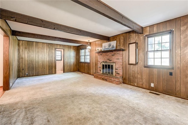 5301 Sycamore Dr, Roeland Park, KS 66205 - unfurnished living room with carpet flooring, wood walls, a brick fireplace, and beamed ceiling