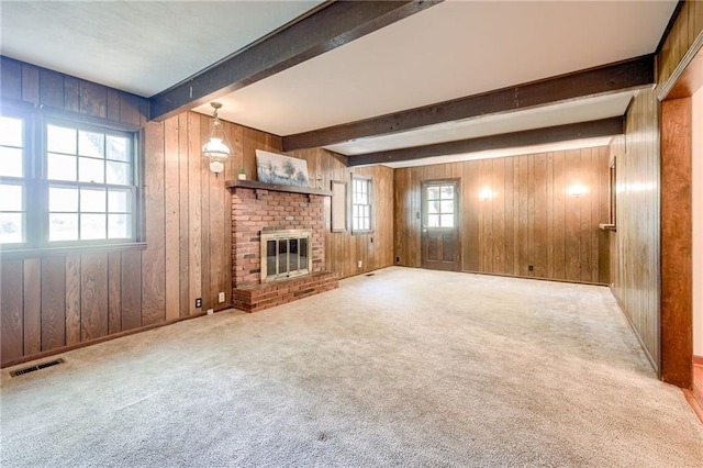 5301 Sycamore Dr, Roeland Park, KS 66205 - unfurnished living room featuring wood walls, beam ceiling, carpet, and a brick fireplace