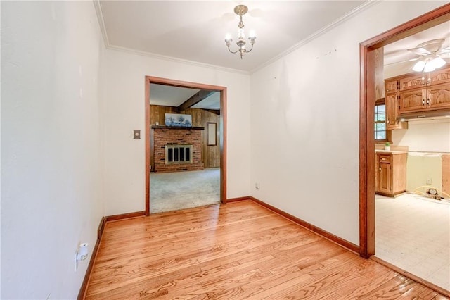 5301 Sycamore Dr, Roeland Park, KS 66205 - unfurnished room with light wood-style floors, a chandelier, a fireplace, crown molding, and a ceiling fan