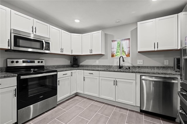 915 4th Ave, Leavenworth, KS 66048 - kitchen with stainless steel appliances, recessed lighting, white cabinets, and dark stone counters