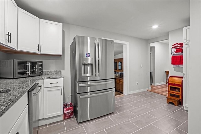 915 4th Ave, Leavenworth, KS 66048 - kitchen with stainless steel appliances, white cabinets, stone countertops, recessed lighting, and light tile patterned flooring