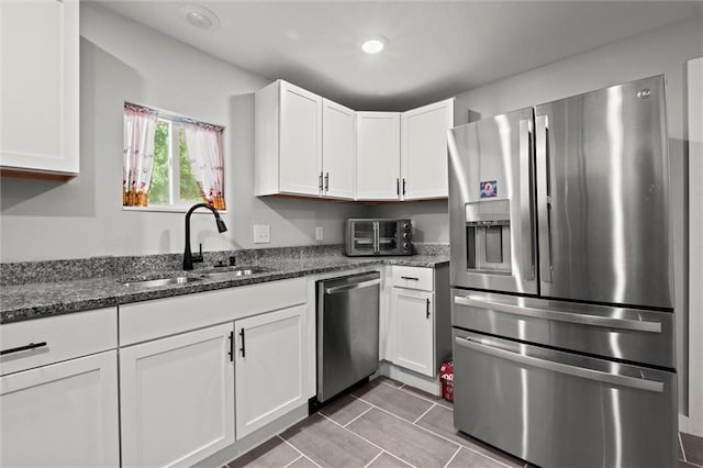 915 4th Ave, Leavenworth, KS 66048 - kitchen with stainless steel appliances, white cabinets, dark stone counters, and tile patterned flooring