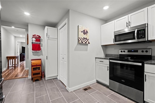 915 4th Ave, Leavenworth, KS 66048 - kitchen featuring appliances with stainless steel finishes, white cabinetry, recessed lighting, and tile patterned floors