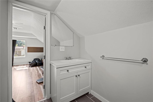 915 4th Ave, Leavenworth, KS 66048 - bathroom featuring lofted ceiling, vanity, and a textured ceiling