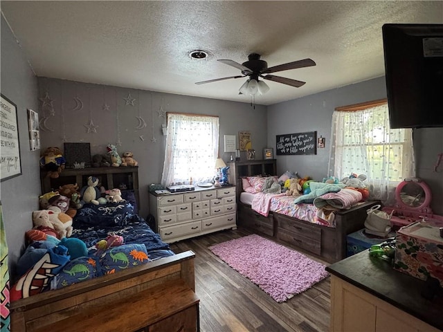 605 N Locust St, Moran, KS 66755 - bedroom featuring dark wood finished floors, a textured ceiling, and a ceiling fan