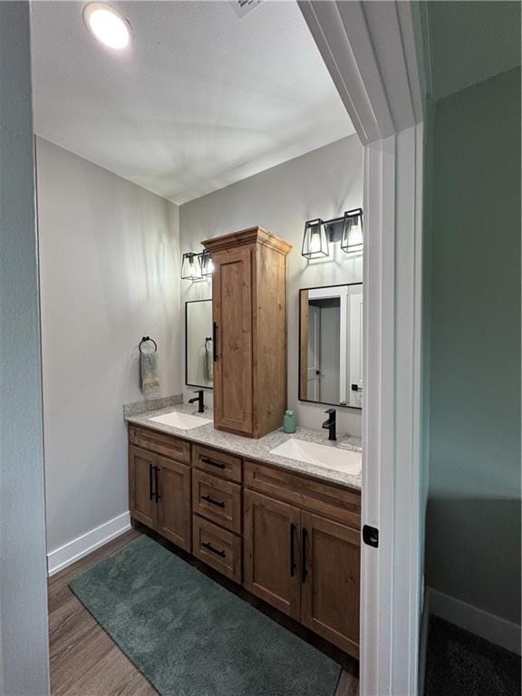 25908 E 317th Ter, Harrisonville, MO 64701 - bathroom featuring double vanity, baseboards, and wood finished floors