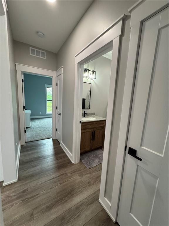 25908 E 317th Ter, Harrisonville, MO 64701 - hall featuring dark wood-style flooring, baseboards, and a sink