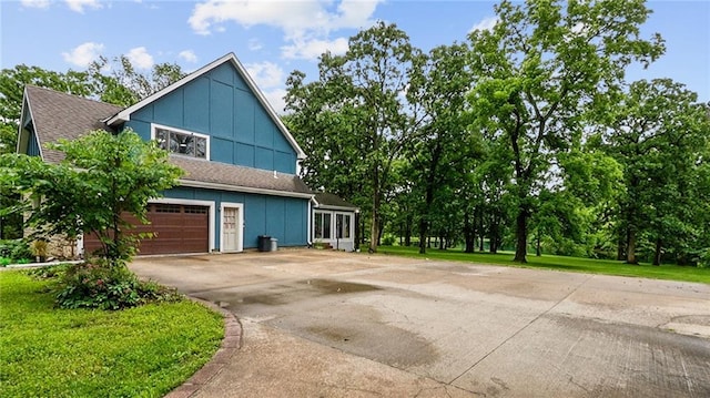26725 S Bennett Rd, Freeman, MO 64746 - view of side of property with board and batten siding, driveway, and an attached garage