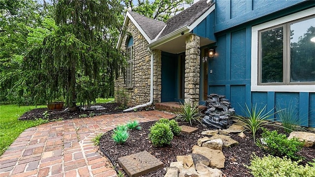 26725 S Bennett Rd, Freeman, MO 64746 - view of exterior entry with stone siding, a shingled roof, and stucco siding