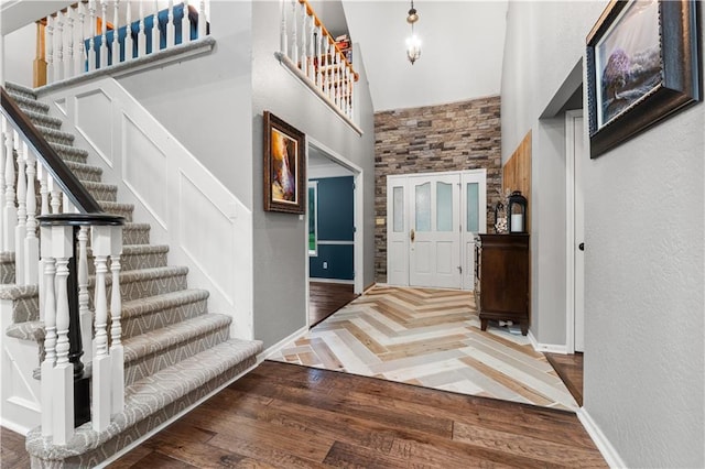 26725 S Bennett Rd, Freeman, MO 64746 - foyer with high vaulted ceiling, parquet floors, stairs, baseboards, and a textured wall