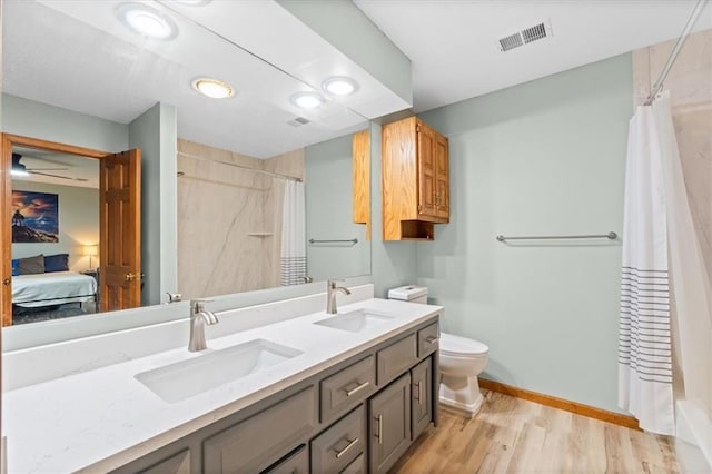 26725 S Bennett Rd, Freeman, MO 64746 - bathroom with double vanity, a shower with shower curtain, wood finished floors, toilet, and connected bathroom