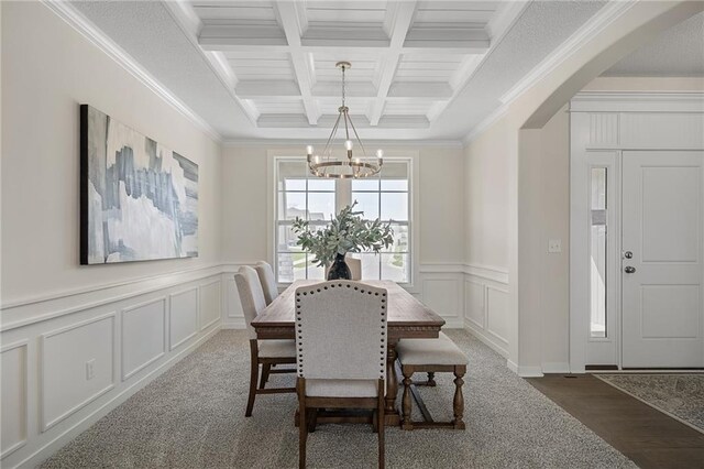 11487 S Cornice St, Olathe, KS 66061 - dining room featuring a chandelier, beam ceiling, coffered ceiling, a decorative wall, and ornamental molding