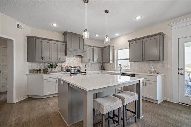 11487 S Cornice St, Olathe, KS 66061 - kitchen with stainless steel appliances, dark wood finished floors, a breakfast bar area, a sink, and recessed lighting