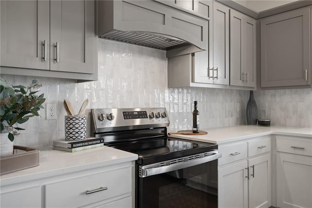 11487 S Cornice St, Olathe, KS 66061 - kitchen featuring stainless steel electric stove, custom exhaust hood, light countertops, and tasteful backsplash