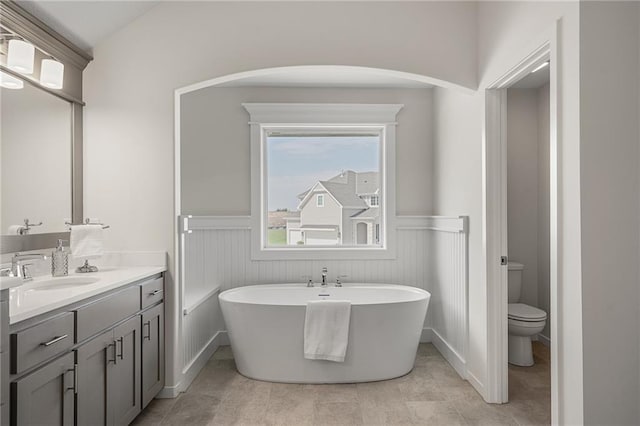 11487 S Cornice St, Olathe, KS 66061 - bathroom featuring vanity, wainscoting, a freestanding bath, and toilet