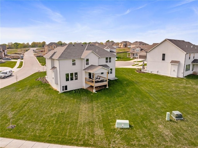 11487 S Cornice St, Olathe, KS 66061 - rear view of house with a residential view, a shingled roof, a lawn, and a wooden deck