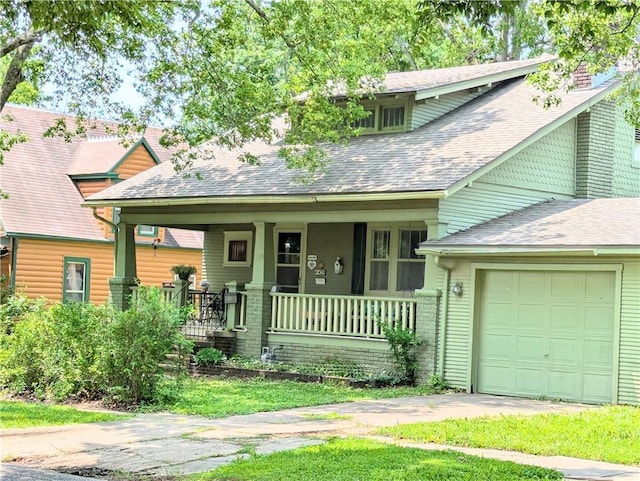 429 N 12th St, Fredonia, KS 66736 - view of front of property featuring a porch, an attached garage, driveway, roof with shingles, and a chimney