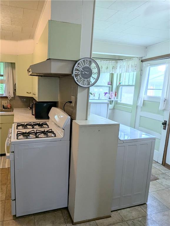 429 N 12th St, Fredonia, KS 66736 - kitchen with white gas range oven, light countertops, white cabinets, and exhaust hood