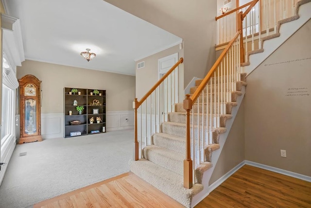 600 N Oak St, Gardner, KS 66030 - staircase with wood finished floors, a wainscoted wall, and crown molding