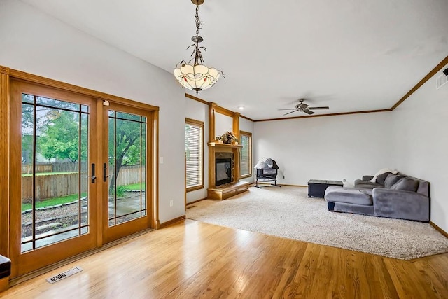 600 N Oak St, Gardner, KS 66030 - living room featuring wood finished floors, a glass covered fireplace, ceiling fan, french doors, and ornamental molding