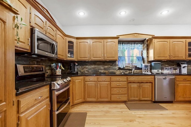 600 N Oak St, Gardner, KS 66030 - kitchen with appliances with stainless steel finishes, tasteful backsplash, glass insert cabinets, light wood finished floors, and recessed lighting