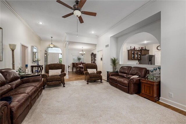 14165 Ashbury Ct, Basehor, KS 66007 - living area with a ceiling fan, crown molding, arched walkways, a chandelier, and baseboards