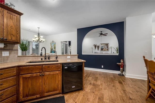 14165 Ashbury Ct, Basehor, KS 66007 - kitchen featuring black dishwasher, a sink, a chandelier, light wood finished floors, and backsplash